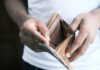 Financial Struggles Lead UK Workers to Favour Weekly Pay A person holding an empty wallet.