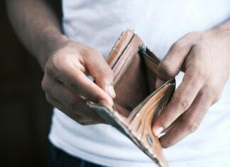 Financial Struggles Lead UK Workers to Favour Weekly Pay A person holding an empty wallet.